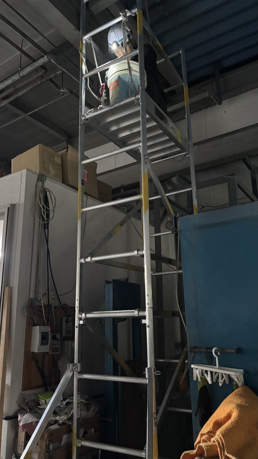 狭いスペースに組んだアルミ足場で作業